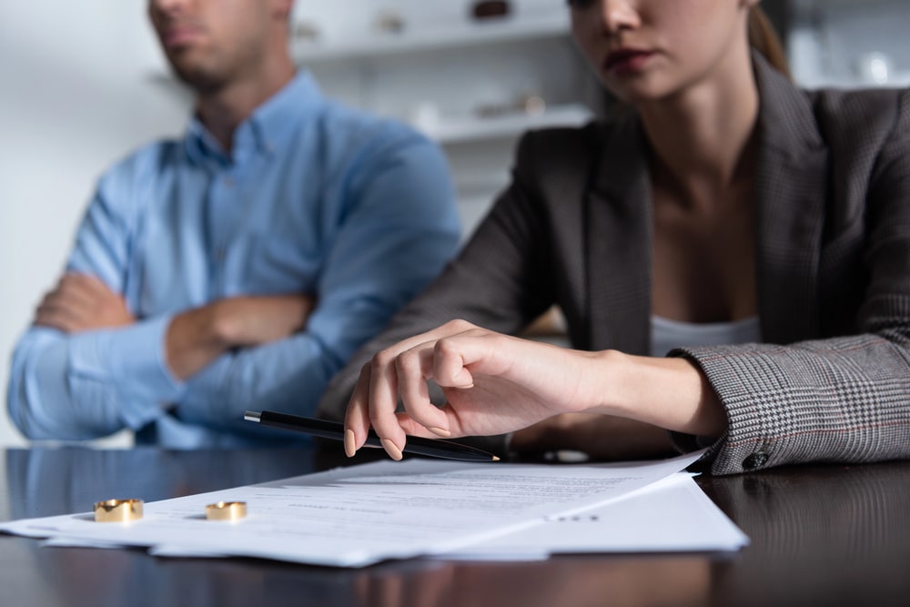 Getting a Divorce Without My Spouses Consent in British Columbia portrayed by an upset man and women signing a divorce contract